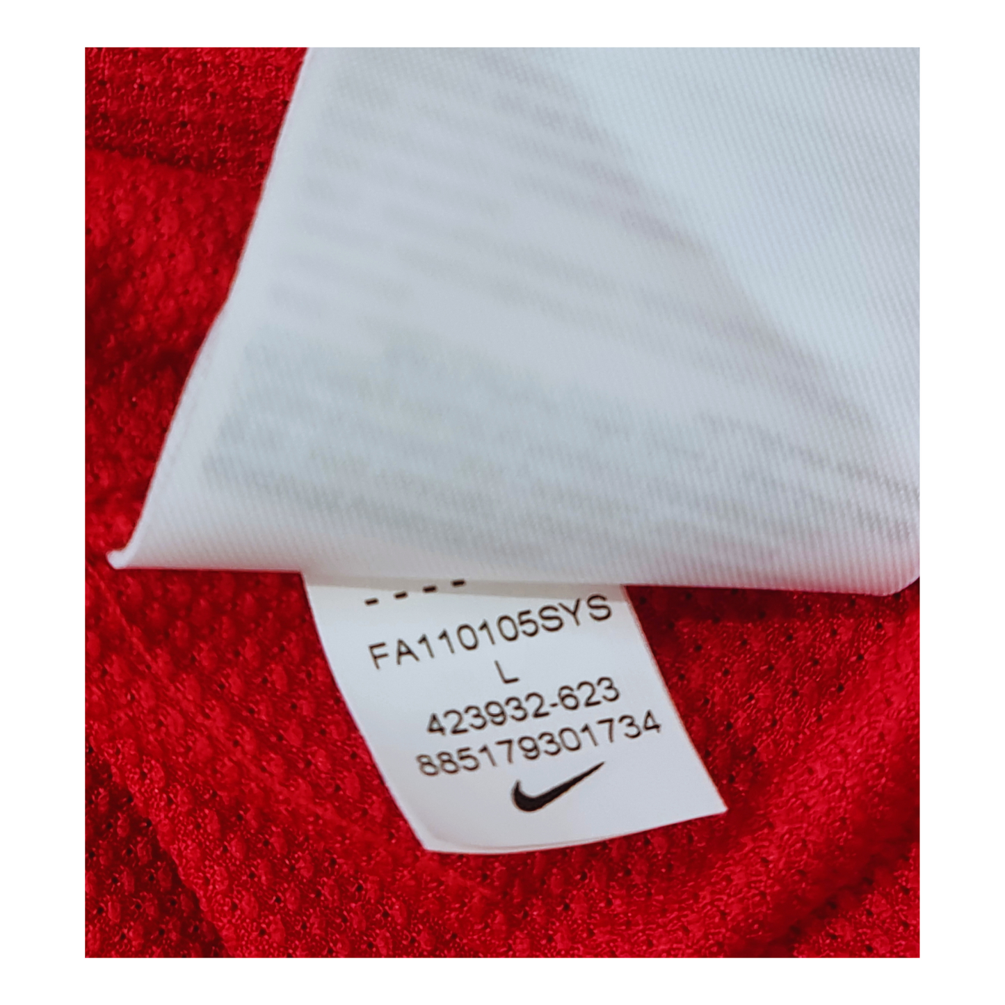 A close up of a label on a red Nike Manchester United 2011/12 Home Jersey.