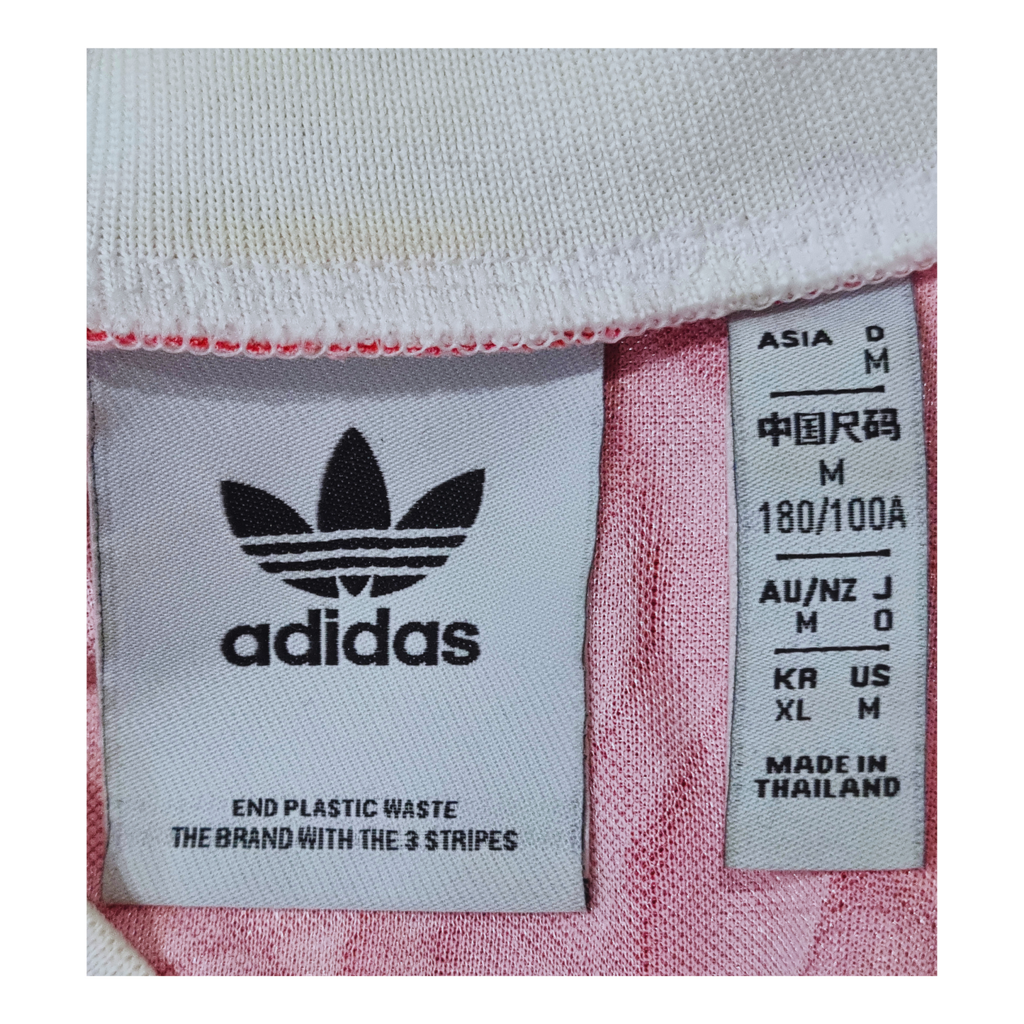 A pink Adidas Manchester United 1991/92 Home Jersey Re-release with a label on it.