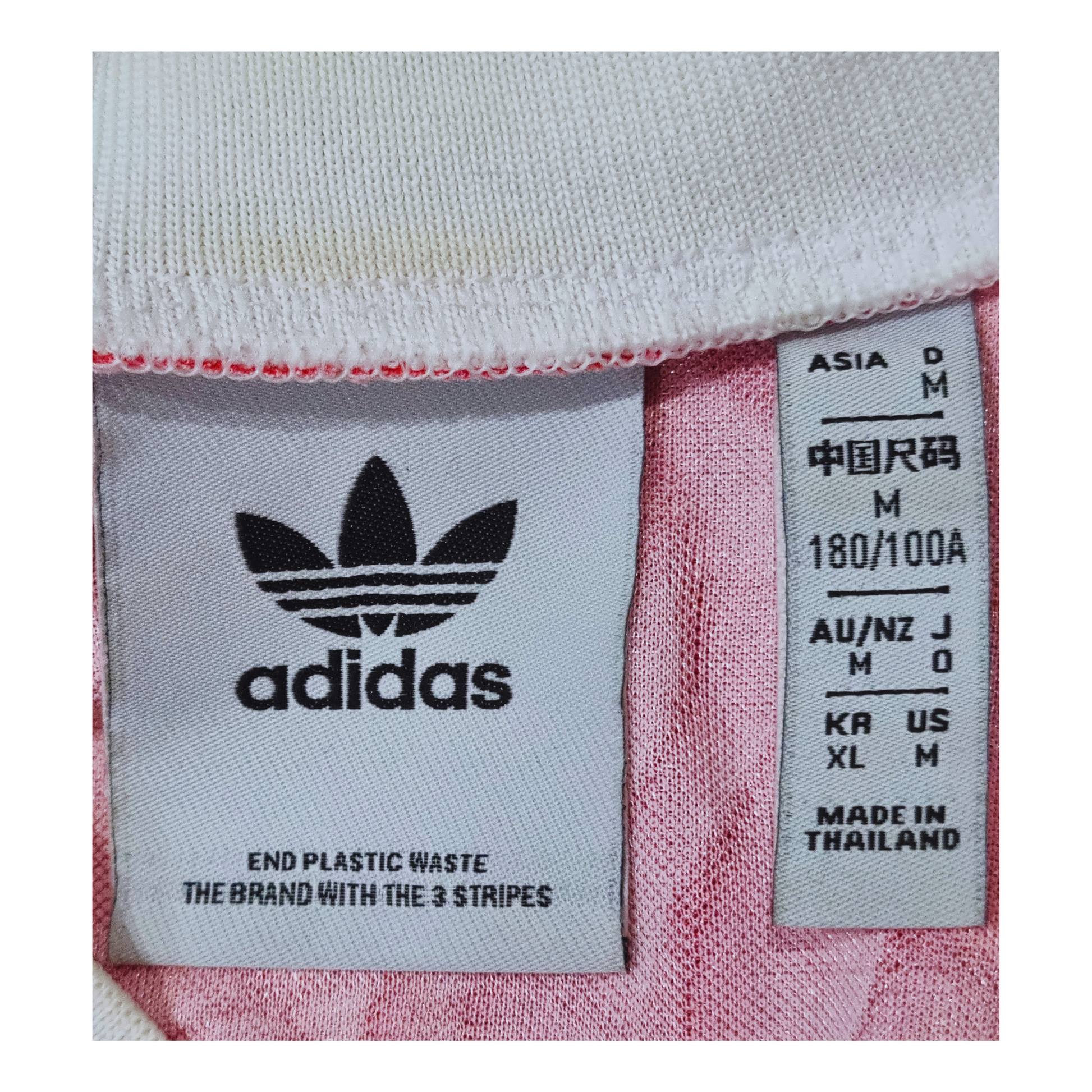 A pink Adidas Manchester United 1991/92 Home Jersey Re-release with a label on it.
